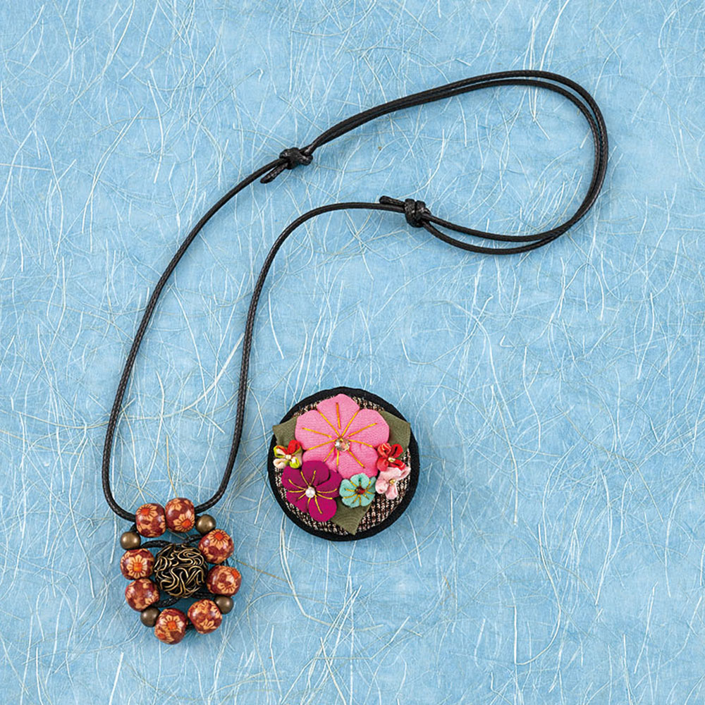 編み込みネックレスと台付き花ブローチ